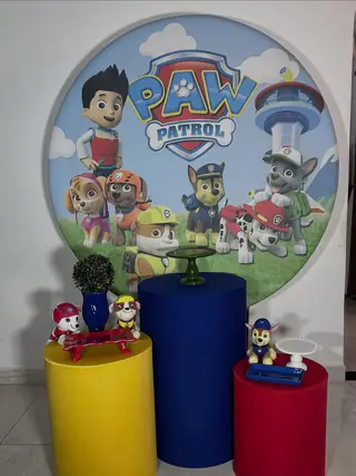 Kit de decoração tema Patrulha Canina: painel redondo com os personagens e três cilindros amarelo, azul e vermelho